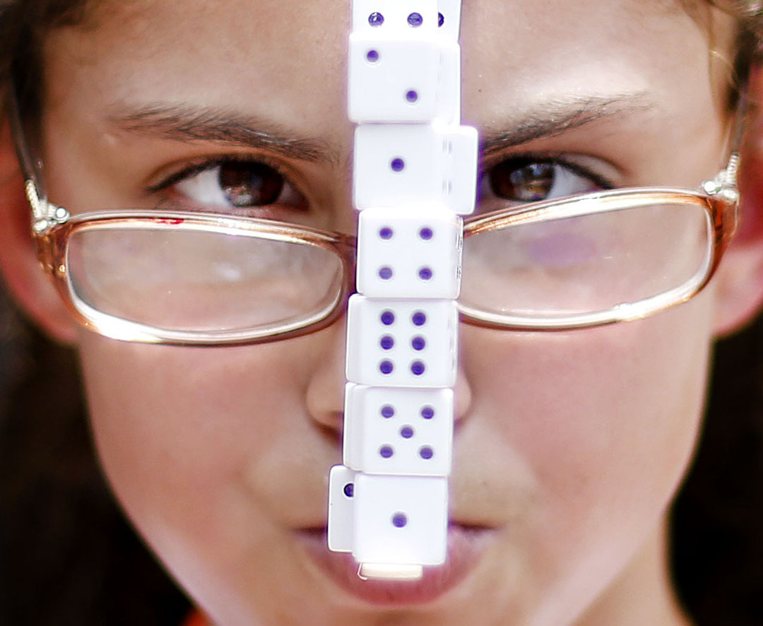Annmarie Harvey concentrates while balancing dice on a popsicle stick in her mouth during a photography session at Herff Jones' The Yearbook Connection Summer Camp on Wednesday, July 22, 2015 in Gainesville, Fla. Other students in the session were taking her photo and trying to capture the moment the dice fell. The three-day camp hosts high and middle school yearbook staffs from around the area and teaches them different aspects of making a yearbook including writing, design, team building and photography. (Matt Stamey/Staff photographer)