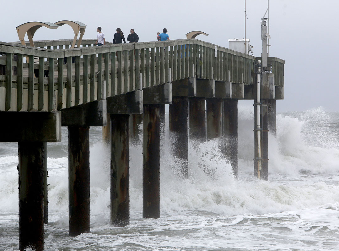 People stand on the pier as waves crash below as Hurricane Matthew approaches on Thursday, Oct. 6, 2016 in St. Augustine, FL. Matt Stamey/Gainesville Sun