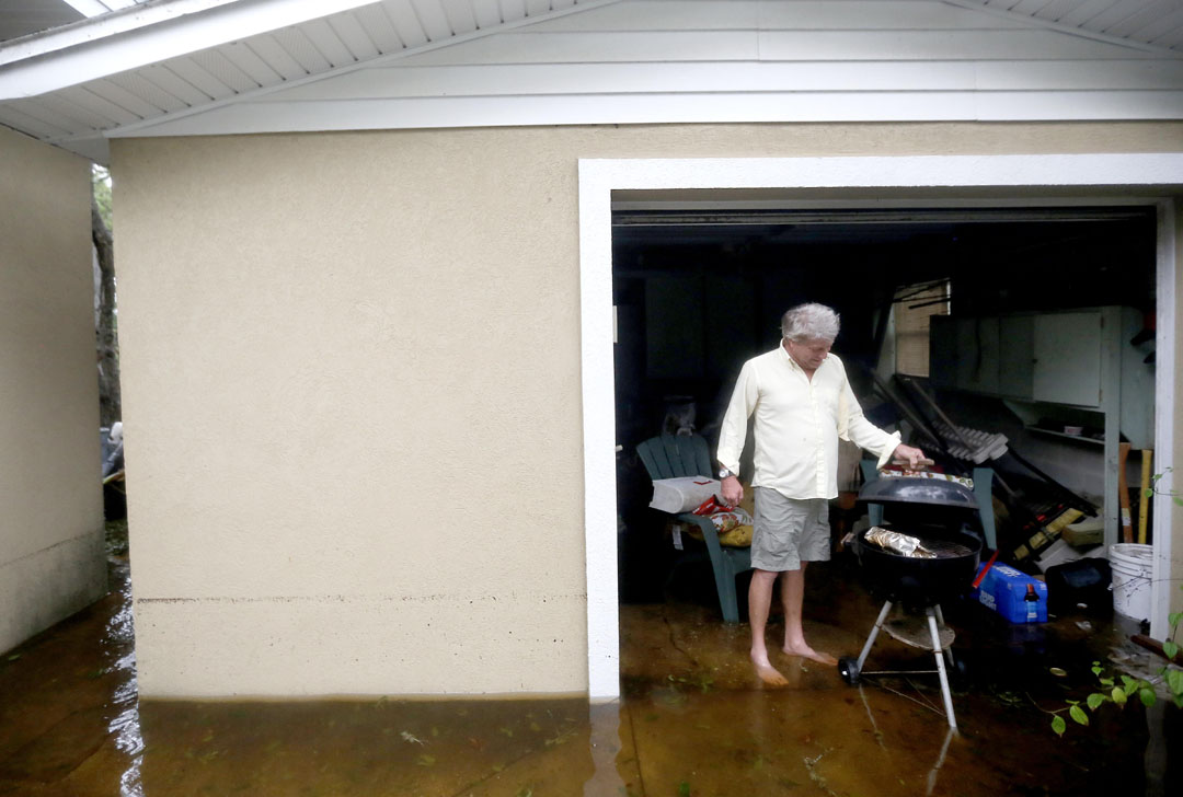 Kelly Bland grills a brisket while standing in floodwaters outside his garage during Hurricane Matthew on Thursday, Oct. 6, 2016 in St. Augustine, FL. Bland rode out the storm at his house just off A1A. Matt Stamey/Gainesville Sun