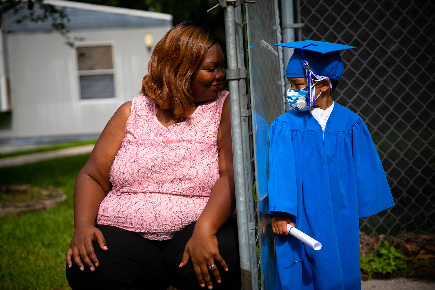 Santa Fe College Little School students were able to pose for a photo with their teachers while wearing a graduation cap and gown on May 27, 2020 in Gainesville, Fla. A plexiglass barrier was put between the teacher and student. (Matt Stamey/Santa Fe College ) ***Subjects Have Releases***