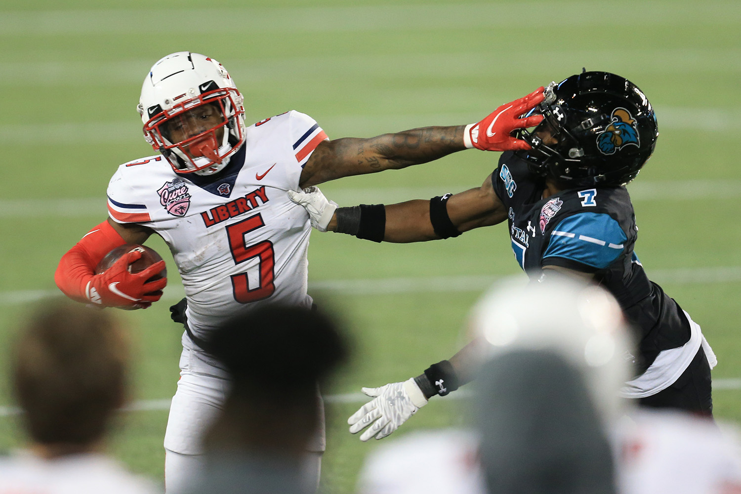 Liberty wide receiver DJ Stubbs (5) stiff arms Coastal Carolina cornerback D'Jordan Strong (7) during the second half of the Cure Bowl NCAA college football game Saturday, Dec. 26, 2020, in Orlando, Fla. (AP Photo/Matt Stamey)