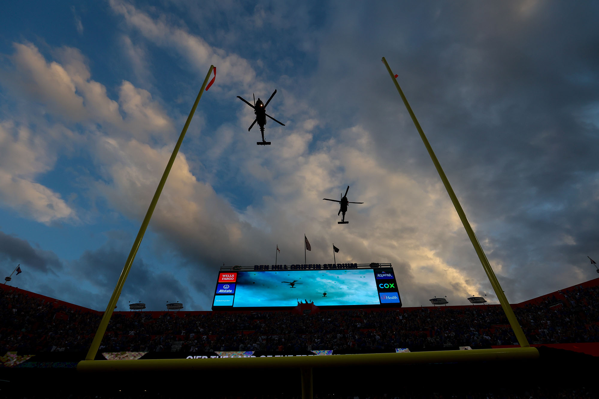 Military helicopters fly over Ben Hill Griffin Stadium during the National Anthem before an NCAA college football game between the Florida Gators and Tennessee Volunteers Saturday, Sept. 25, 2021, in Gainesville, Fla. (Matthew Stamey via AP)